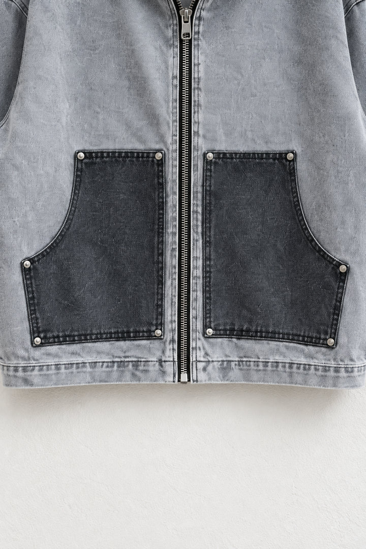 Detaliu al buzunarelor antracit, niturilor și fermoarului jachetei din denim gri