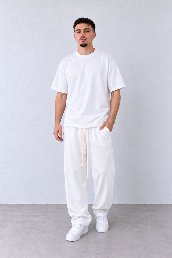 Pantaloni Baggy Felpați Bărbați Albi, vedere integrală pe model cu capul ușor întors sau înclinat.