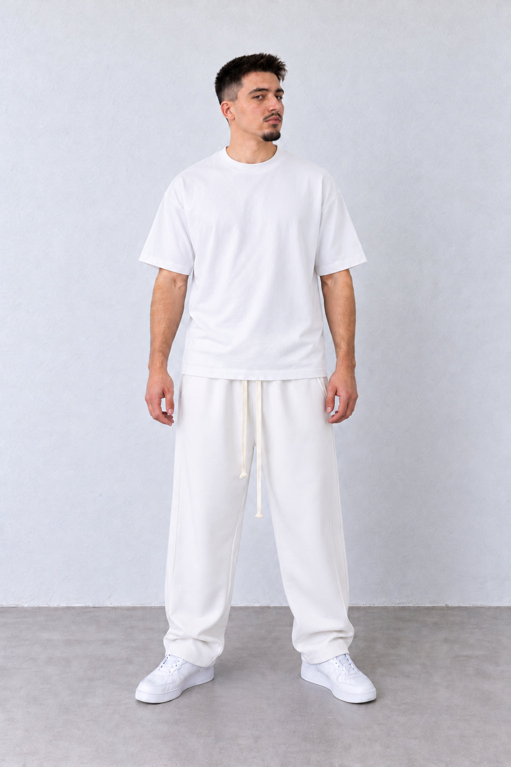 Pantaloni Baggy Felpați Bărbați Albi, vedere pe model cu poziție alternativă a brațelor și picioarelor.