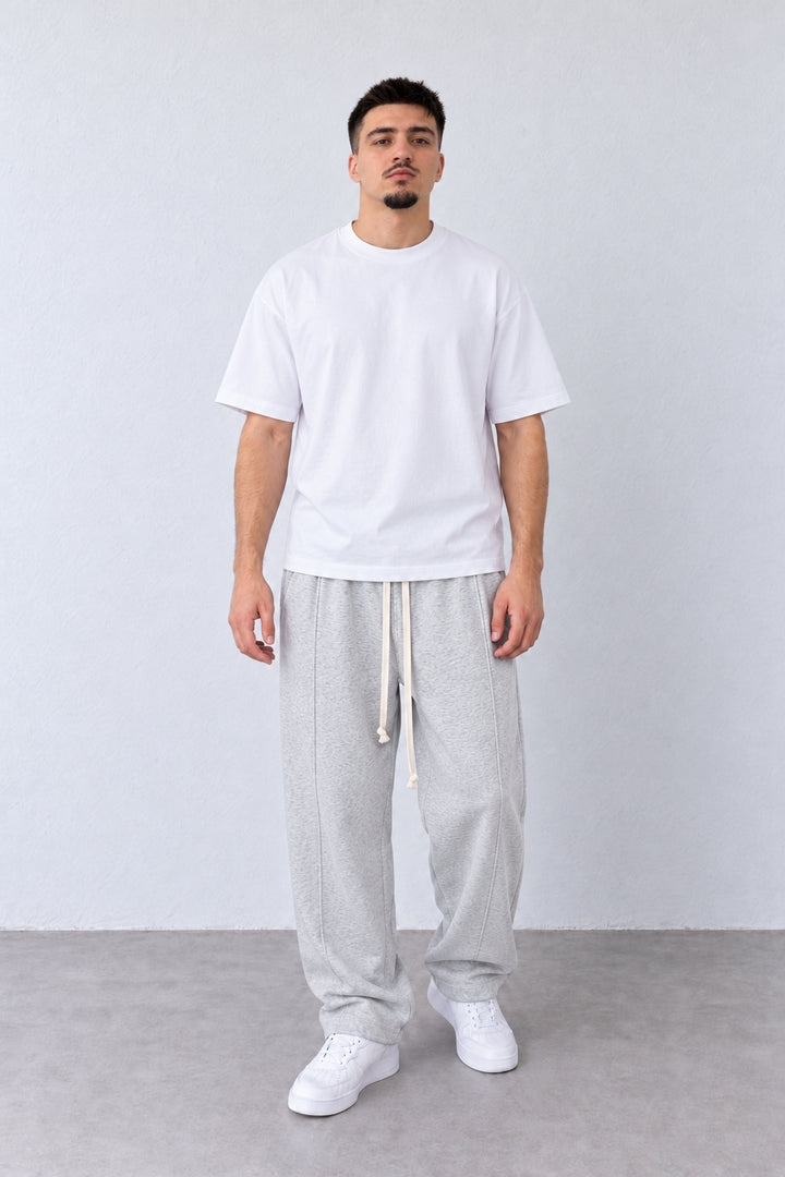 Pantaloni Baggy Felpați Bărbați Gri Melanj, vedere pe model cu poziție alternativă a brațelor și picioarelor.