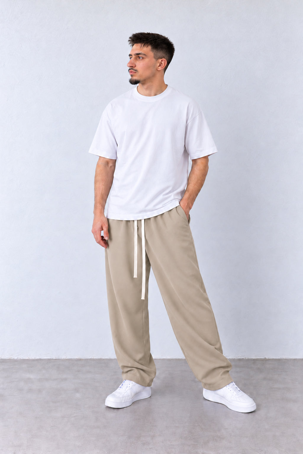 Bézs férfi baggy nadrág. Modellen, laza pózban.