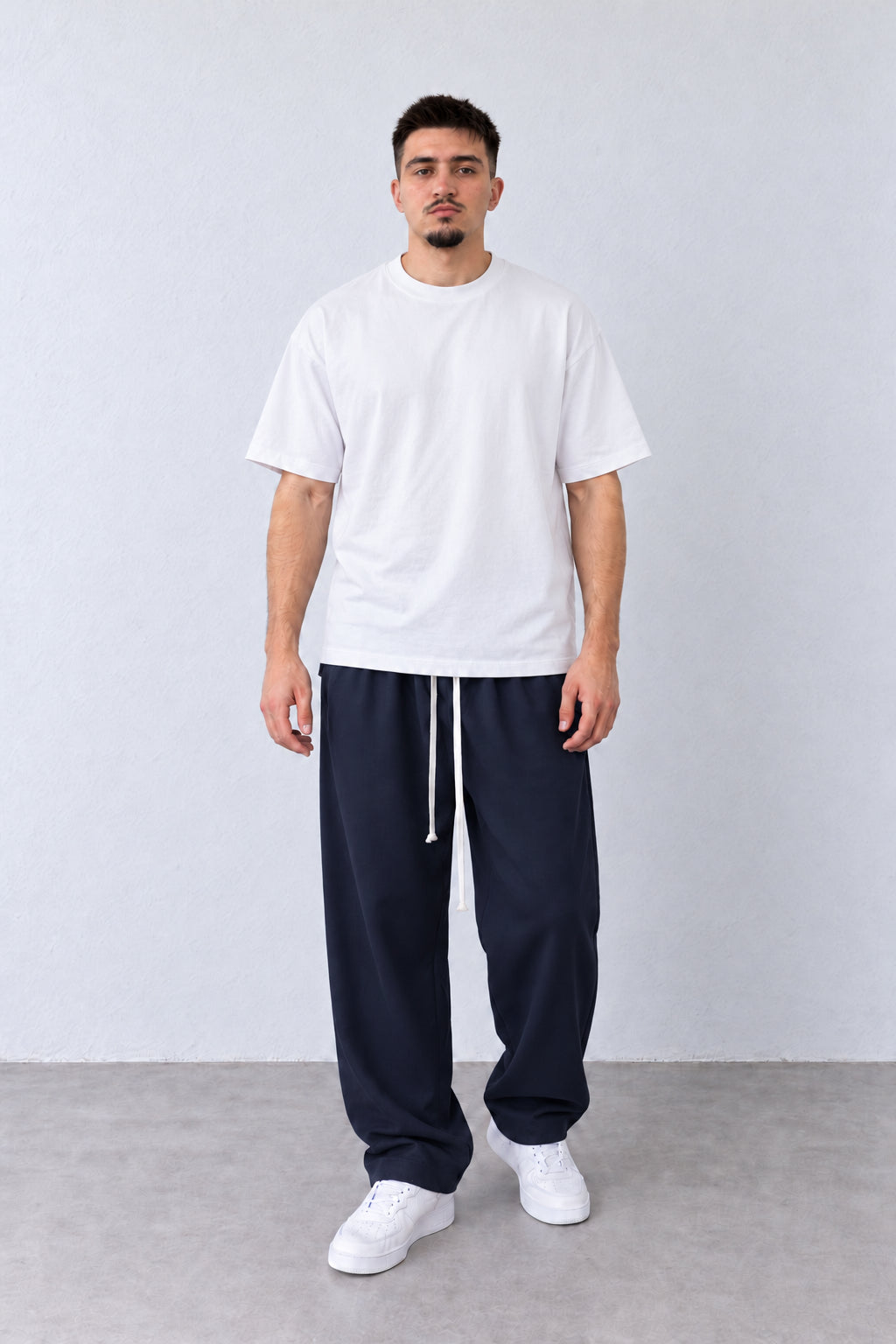 Sötétkék férfi baggy nadrág. Modellen, enyhén elfordított fejjel.