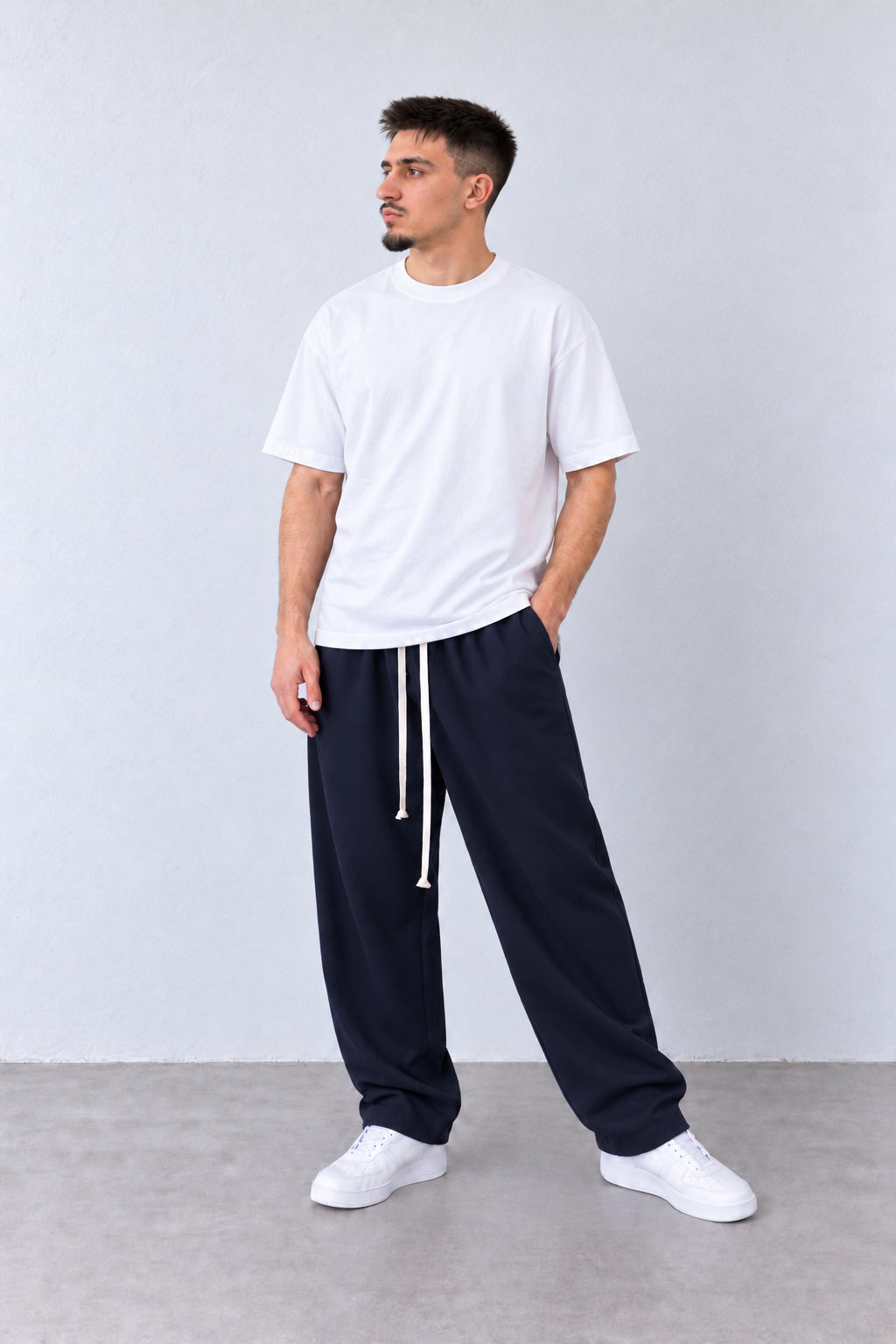 Sötétkék férfi baggy nadrág. Modellen, laza pózban.