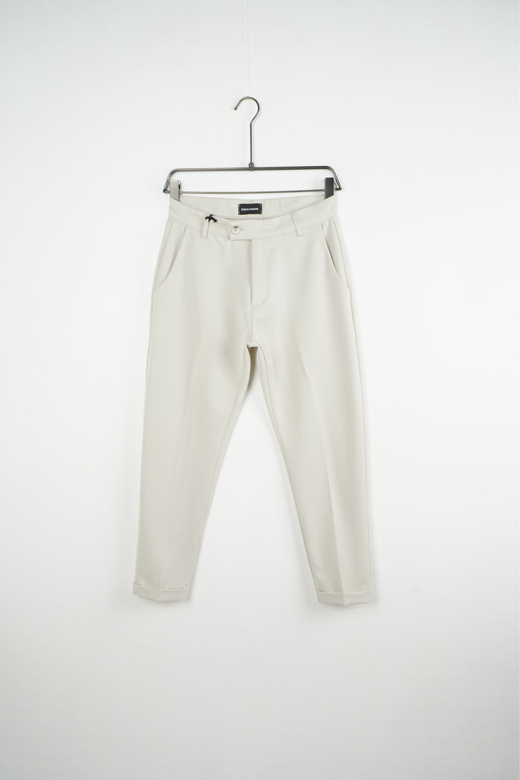 Krémszínű férfi slim fit nadrág. Termékfotó vállfán, elölnézetből.