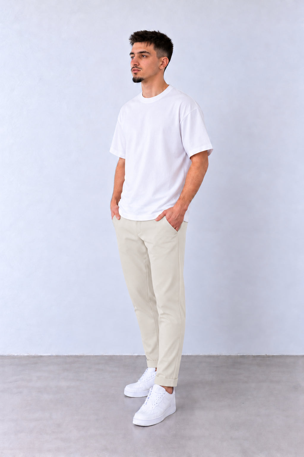 Krémszínű férfi slim fit nadrág. Modellen, enyhén elfordított fejjel.