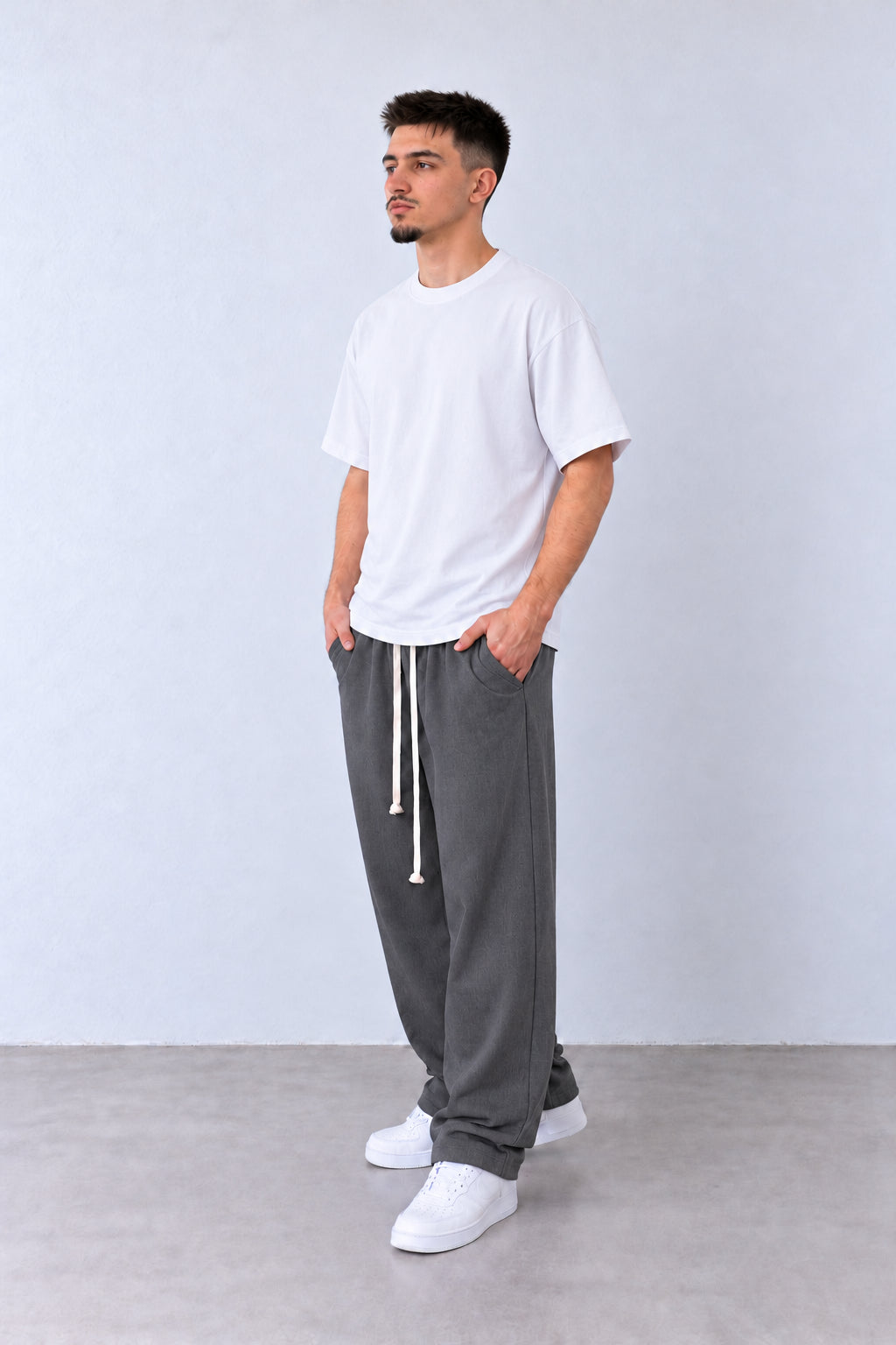 Szürke férfi baggy nadrág elülső varrásokkal. Modellen, laza pózban.