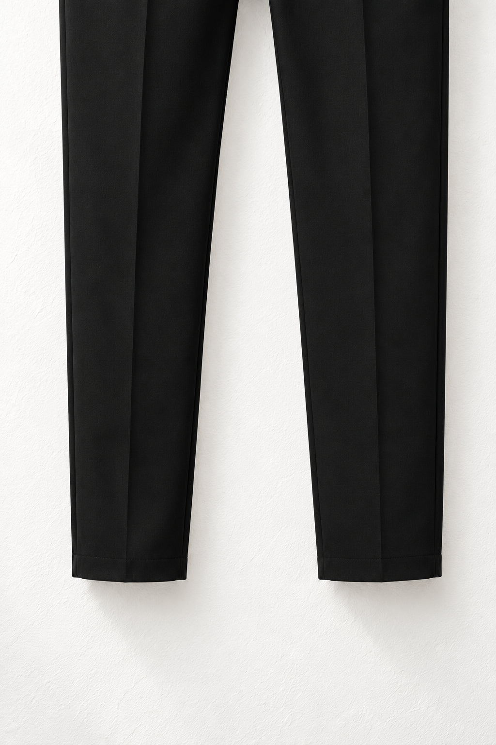 Detaliu material fin și tiv simplu la pantalonii slim negri