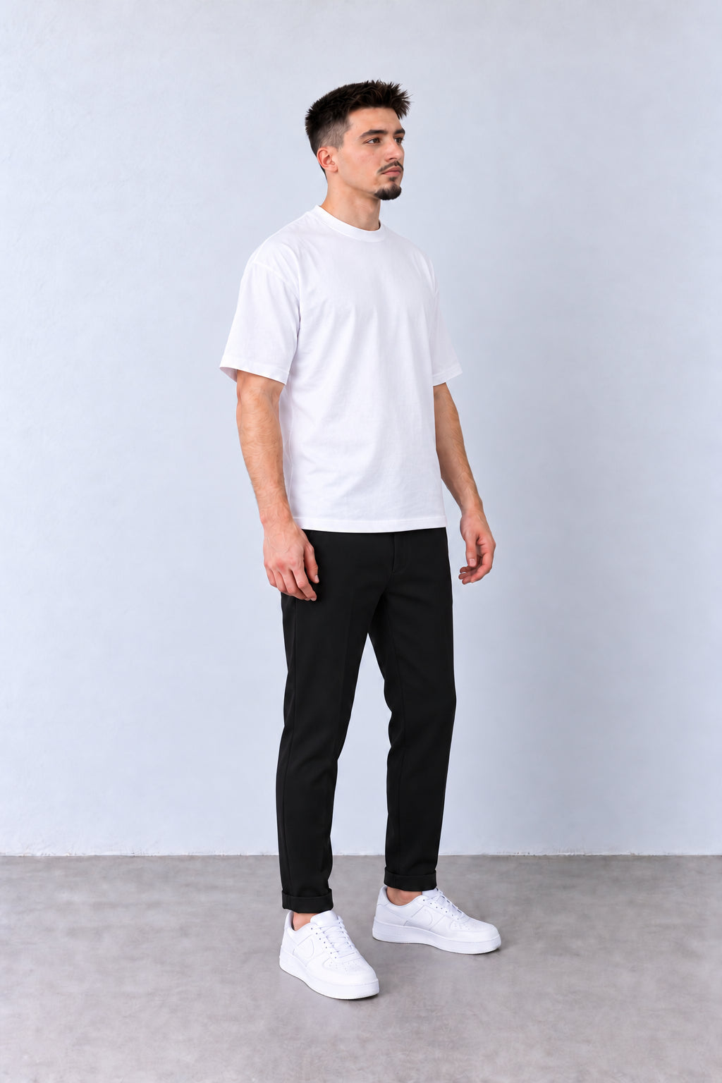 Fekete férfi slim fit nadrág. Modellen, enyhén elfordított fejjel.