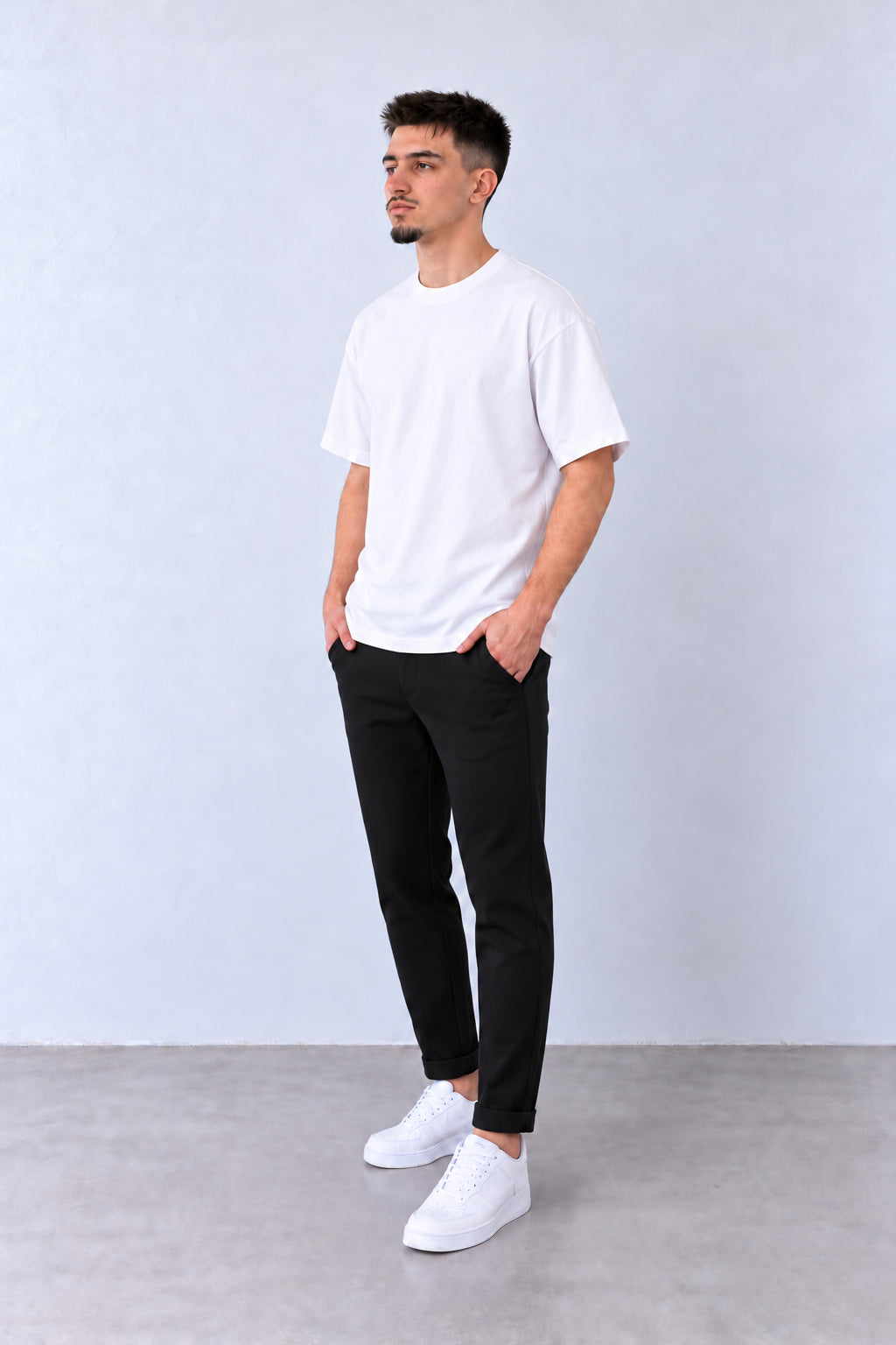 Fekete férfi slim fit nadrág. Modellen, laza pózban.