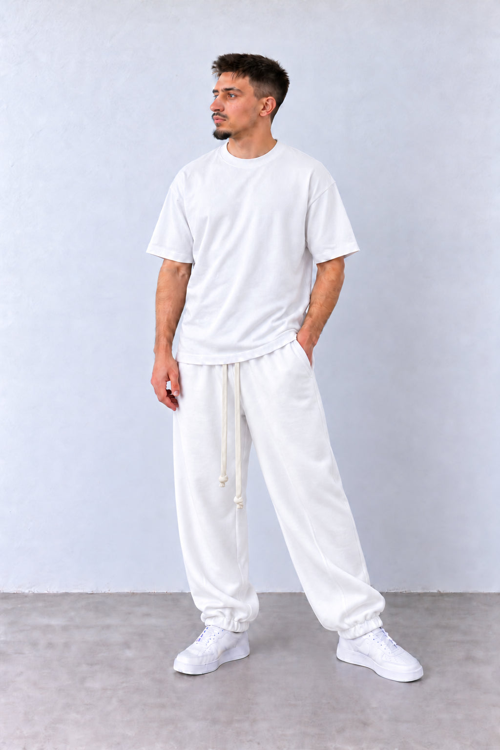 Fehér férfi pamut jogger nadrág. Modellen, enyhén elfordított fejjel.