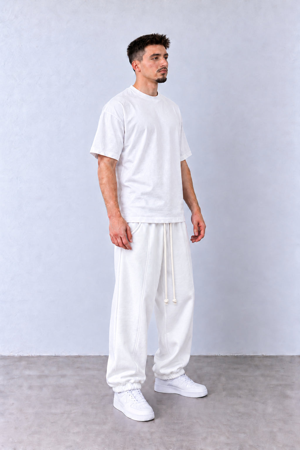 Fehér férfi pamut jogger nadrág. Modellen, laza pózban.