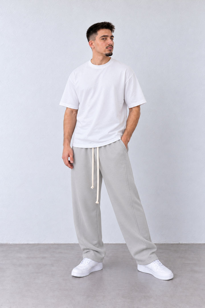 Pantaloni Largi Bărbați Gri Gheață Felpați cu Șnur Lung, vedere pe model cu poziție alternativă a brațelor și picioarelor.