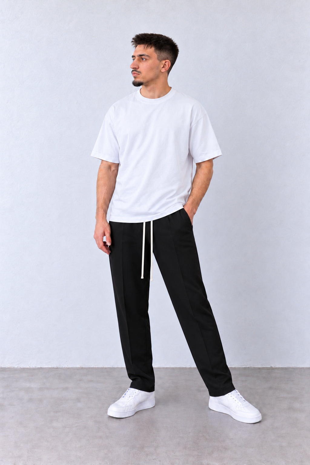 Pantaloni Slim Bărbați Negri cu Șnur Lung, vedere pe model cu poziție alternativă a brațelor și picioarelor.