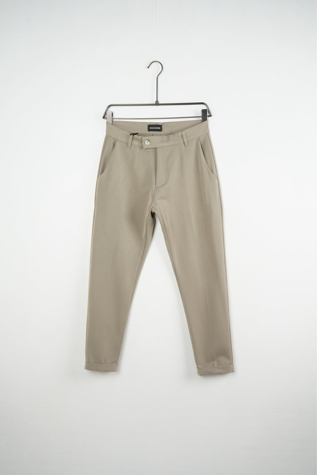 Bézs férfi slim fit nadrág. Termékfotó vállfán, elölnézetből.