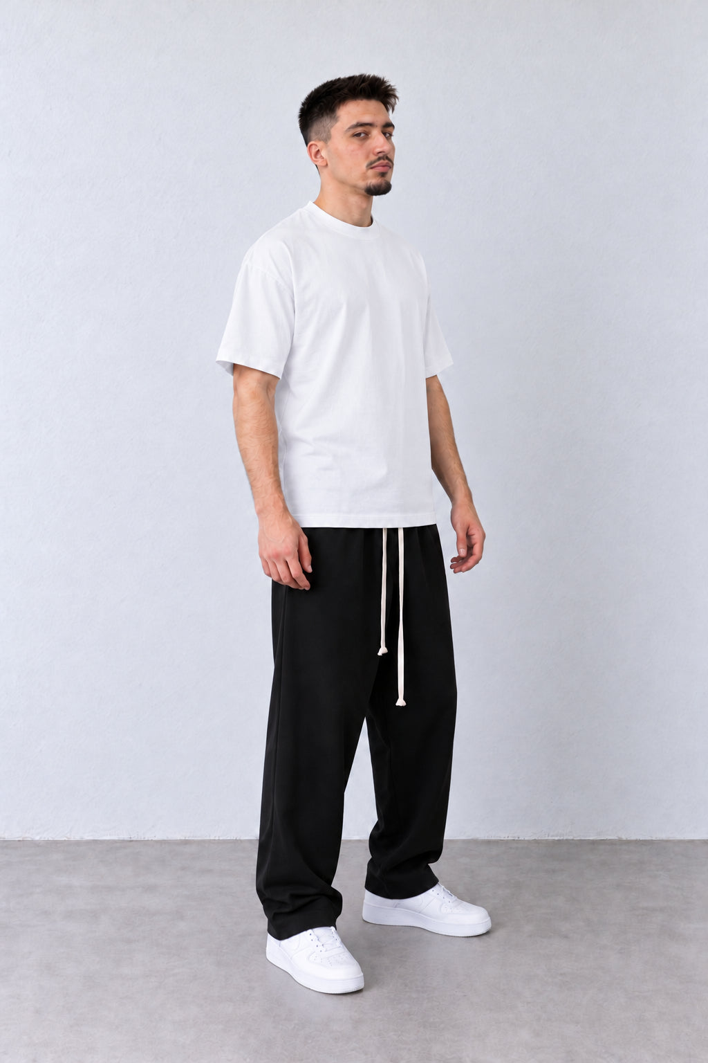 Fehér férfi pamutpóló laza szabással. Modellen, laza pózban.